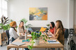 © Studio Marmellata/Stocksy - Cheerful multiracial coworkers having meeting in creative workspace