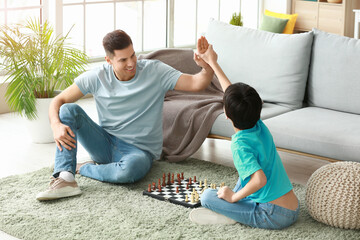 Poster - Father and son playing chess at home