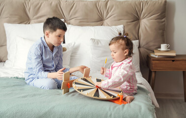 Poster - Cute little children with toys sitting on bed