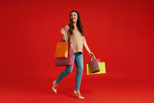 Full Length Of Beautiful Young Woman In Casual Clothing Carrying Shopping Bags