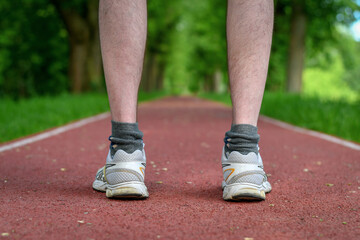 Runner feet standing on the running track in the park. 