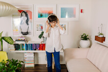 Teen Boy Dancing And Singing In Colorful Room With Books And Photo Wall Gallery