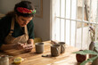 © Malquerida Studio/Stocksy - Ceramist young woman Making Clay cups  in her studio