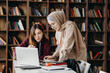 © Stereo Shot/Stocksy - Young diverse female students preparing for exams together in library