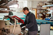 © David Prado/Stocksy - Crop worker cutting metal aluminum at factory