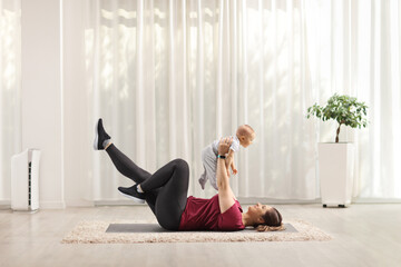 Canvas Print - Mother exercising with her baby on a mat