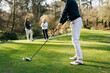 © Sergio Marcos/Stocksy - Women playing golf in park