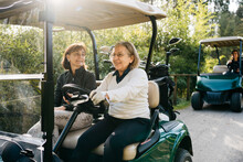 Women Driving Golf Carts In Park