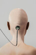 © Marcos Osorio/Stocksy - Rear view of a shaved head with a wire attached to the head