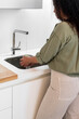 © Bisual Studio/Stocksy - Housewife washing fruit under tap in kitchen