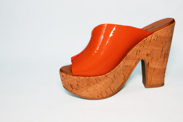 Closeup of a trendy and eye-catching orange cork wedge shoe for women isolated on white background. Perfect for fashion and lifestyle concepts