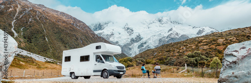 Motorhome camper van RV road trip on New Zealand. Couple on travel vacation adventure. Tourists looking at view of Aoraki Mount Cook National park and mountains next to rental car. Panoramic banner