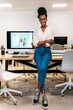 © VICTOR TORRES/Stocksy - A happy confident black creative woman at the office