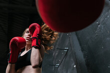 Fit Boxer Training And Punching The Punching Bag At A Boxing Club
