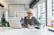 © Mihajlo Ckovric/Stocksy - Portrait of a senior businesswoman working in the office