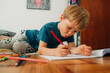 © Olga Moreira/Stocksy - Little boy focused while drawing