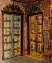 Two Vintage Wooden Doors In Arched Doorframes