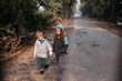 © Amanda Voelker/Stocksy - A little girl and little boy walk together along a path in wetlands
