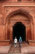 © Amanda Voelker/Stocksy - Two young children walk together through an archway in an Indian palace