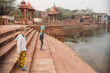 © Amanda Voelker/Stocksy - A little boy and little girl stand in an ancient Indian water temple