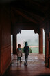 © Amanda Voelker/Stocksy - Two young children walk together through an archway in an Indian palace