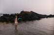 © Amanda Voelker/Stocksy - A young girl on rock in the ocean at sunset