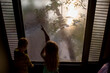 © Amanda Voelker/Stocksy - Two Children drawing on steamy windows
