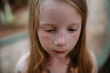 © Amanda Voelker/Stocksy - Portrait of a young girl with freckles in a tropical setting