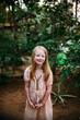 © Amanda Voelker/Stocksy - Portrait of a young girl with freckles in a tropical setting