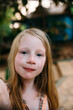 © Amanda Voelker/Stocksy - Portrait of a young girl with freckles in a tropical setting