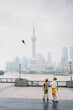 © Amanda Voelker/Stocksy - Two young children watching a kite on the Bund in Shanghai
