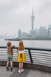 © Amanda Voelker/Stocksy - Two young children looking at the Shanghai Skyline