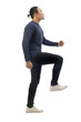 © airdone - Man wearing casual blue shirt black denim and white shoes, looking up forward and stepping high, side view climbing stair gesture. Full body portrait isolated