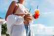 © Viktor Solomin/Stocksy - Young tanned woman enjoying cocktails in summer.