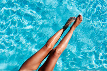 Tanned Woman Legs In Summer Pool 