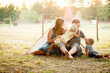 © Jennifer Bogle/Stocksy - Laughing family sitting together  on ground