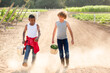 © Jennifer Bogle/Stocksy - Boys walking on dusty farm road