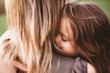 © Lea Csontos/Stocksy - Daughter embracing her mother with closed eyes