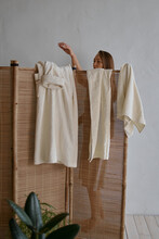  Woman Stands Behind A Bamboo Screen And Changes Into A White Cotton Robe