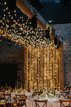 Wedding Reception Tables Indoors With A Lot Of String Lights And Candles