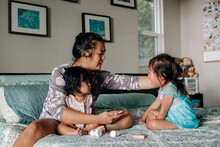 Deaf Mother On Bed Caring For Sick Daughters