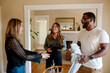 © Erin Brant/Stocksy - Smiling biracial couple discussing home tour with happy real estate agent