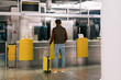 © Alina Hvostikova/Stocksy - Unrecognizable traveler waiting near registration desk