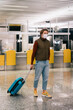 © Alina Hvostikova/Stocksy - Guy with luggage walking in airport terminal