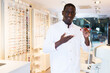 © JackF - Professional male optician standing and offering glasses in medical shop