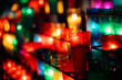 © Guaita Studio/Stocksy - Arrangement of colorful lit candles in the dark
