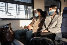 Couple With Luggage Sitting In Train During Pandemic