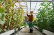 © Milles Studio/Stocksy - Female gardener with watering can checking plant