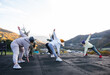 © Milles Studio/Stocksy - Unrecognizable female athletes exercising on terrace near mountains