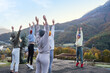 © Milles Studio/Stocksy - Trainer showing exercise to sportswomen near mountains